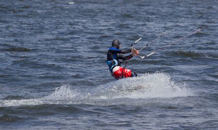 kitesurfer glides on water view from the backの写真素材