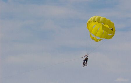 Happy people flying parasailing on the beach.の写真素材