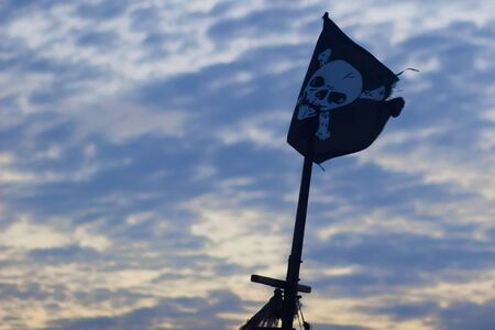 Jolly Roger (pirate flag) against storm cloudsの写真素材