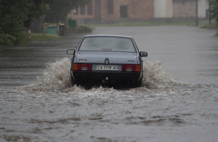 CHERKASSY, UKRAINE- JUNE 27, 2015: cars driving on a flooded road during a flood caused by heavy rain, in Cherkassy.のeditorial素材
