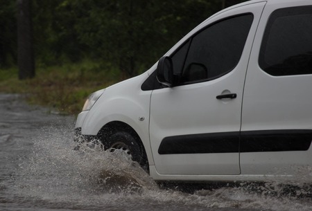 CHERKASSY, UKRAINE- JUNE 27, 2015: cars driving on a flooded road during a flood caused by heavy rain, in Cherkassy.のeditorial素材
