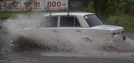 CHERKASSY, UKRAINE- JUNE 27, 2015: cars driving on a flooded road during a flood caused by heavy rain, in Cherkassy.のeditorial素材