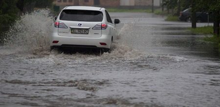 CHERKASSY, UKRAINE- JUNE 27, 2015: cars driving on a flooded road during a flood caused by heavy rain, in Cherkassy.のeditorial素材