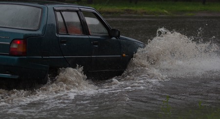 CHERKASSY, UKRAINE- JUNE 27, 2015: cars driving on a flooded road during a flood caused by heavy rain, in Cherkassy.のeditorial素材