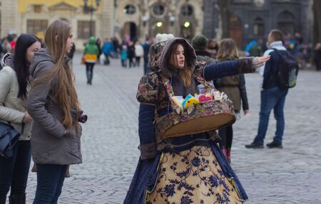 LVIV, UKRAINE - November 15: The girl in a beautiful suit sells candy in Lviv Market Square landmark November 15, 2015 in Lviv, Ukraine.のeditorial素材