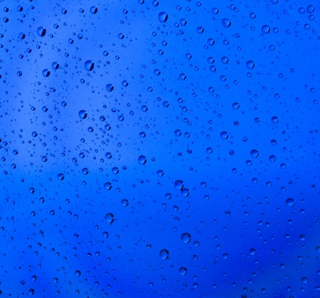 Background of blue water drops on glassの写真素材