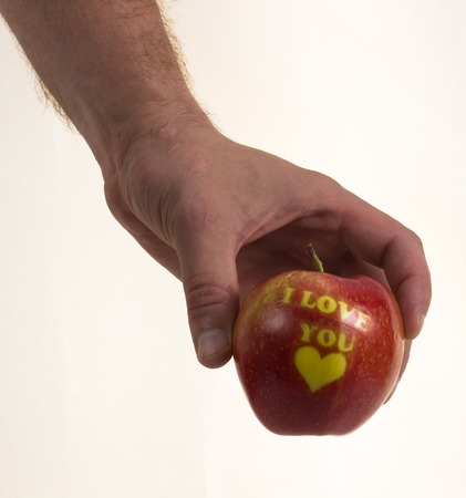 red apple in hand on white background. I love you