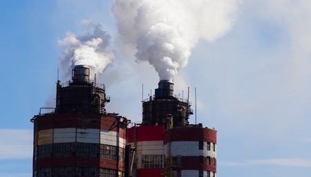 industrial smoke from chimney on blue sky.