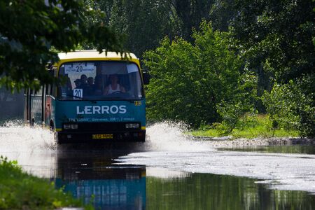 CHERKASSY, UKRAINE- JUNE 5, 2016: cars driving on a flooded road during a flood caused by heavy rain, in Cherkassy.のeditorial素材