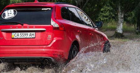 CHERKASSY, UKRAINE- JUNE 5, 2016: cars driving on a flooded road during a flood caused by heavy rain, in Cherkassy.のeditorial素材