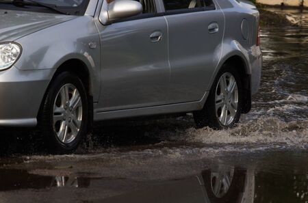 CHERKASSY, UKRAINE- JUNE 5, 2016: cars driving on a flooded road during a flood caused by heavy...