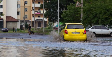 CHERKASSY, UKRAINE- JUNE 5, 2016: cars driving on a flooded road during a flood caused by heavy rain, in Cherkassy.のeditorial素材