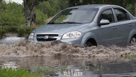 CHERKASSY, UKRAINE- JUNE 5, 2016: cars driving on a flooded road during a flood caused by heavy...