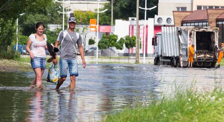 CHERKASSY, UKRAINE- JUNE 5, 2016: cars driving on a flooded road during a flood caused by heavy rain, in Cherkassy.のeditorial素材