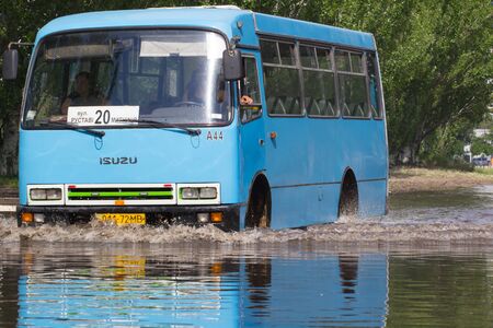 CHERKASSY, UKRAINE- JUNE 5, 2016: cars driving on a flooded road during a flood caused by heavy rain, in Cherkassy.のeditorial素材