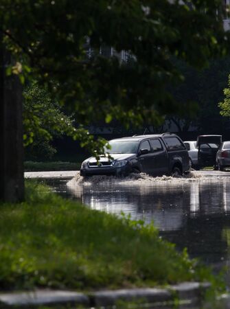 CHERKASSY, UKRAINE- JUNE 5, 2016: cars driving on a flooded road during a flood caused by heavy rain, in Cherkassy.のeditorial素材