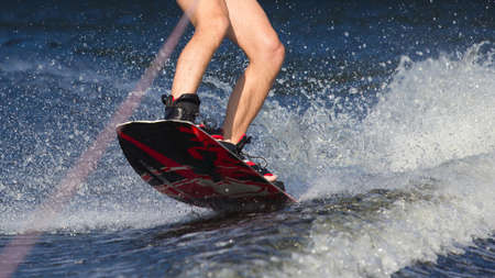 Young man riding wakeboard on a summer lake