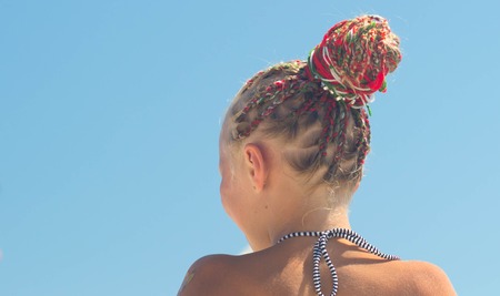 Hairstyle with many small plaited braids. Summertime outdoors close-up image.の写真素材