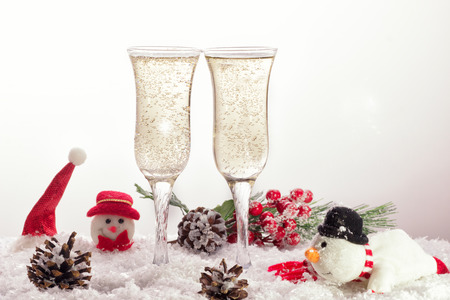 Two glasses with champagne on the snow in Christmas timeの写真素材