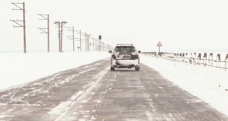 Cars with winter tires on snow-covered roadの写真素材