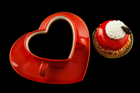 Red cup of coffee in the shape of a heart for lovers on a black backgroundの写真素材