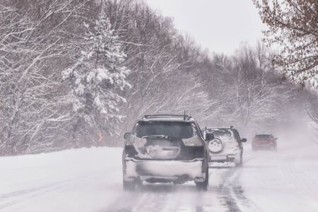Cars with winter tires on snow-covered roadの写真素材