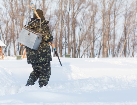 winter fishing. The man with the drill on the ice.の写真素材