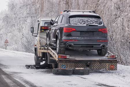 warning triangle with winter car breakdown in background.の写真素材