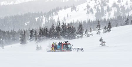 Catskiing, cat, ratrack is unloading skiers for drop, skiing at the top of mountain. Freeride snowboards, Action and adventure for winterの写真素材