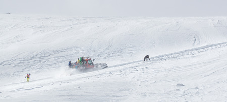 Ratrack is unloading skiers for drop, skiing at the top of mountain. Freeride snowboards, Action and adventure for winterの写真素材