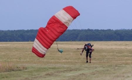 Sutiski, Ukraine - June 24, 2017: Skydivers carries a parachute after landing. Skydive Ukraine is the skydiving center located at Sutiski Aerodrome, about 20 km southwest of Vinitsa, Ukraine.のeditorial素材