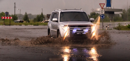 Car traffic in a heavy rain on a flooded city road