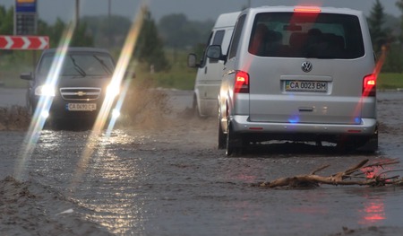 SHPOLA, UKRAINE- JULY 28, 2017: cars driving on a flooded road during a flood caused by heavy rain, in Shpolaのeditorial素材