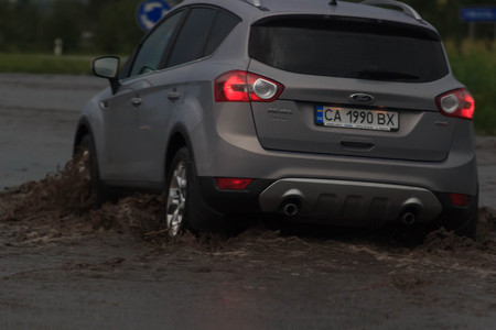 SHPOLA, UKRAINE- JULY 28, 2017: cars driving on a flooded road during a flood caused by heavy rain, in Shpolaのeditorial素材