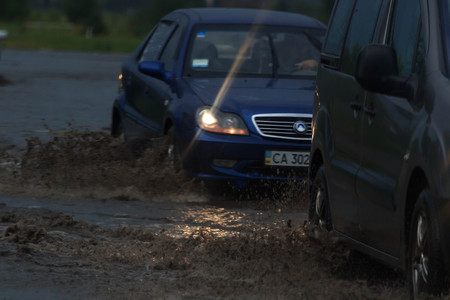 SHPOLA, UKRAINE- JULY 28, 2017: cars driving on a flooded road during a flood caused by heavy rain, in Shpolaのeditorial素材
