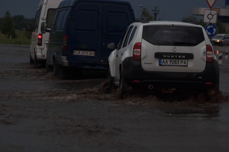 SHPOLA, UKRAINE- JULY 28, 2017: cars driving on a flooded road during a flood caused by heavy rain, in Shpolaのeditorial素材