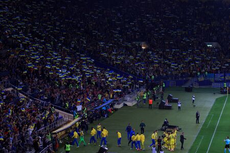 KHARKIV, UKRAINE - SEPTEMBER 2, 2017: Ukrainian fans with huge flag of Ukraine and logo of Football Federation. FIFA World Cup 2018 qualifying match Ukraine - Turkey. Metalist Stadium.のeditorial素材