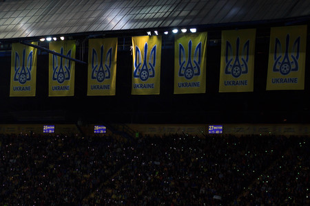 KHARKIV, UKRAINE - SEPTEMBER 2, 2017: Ukrainian fans with huge flag of Ukraine and logo of Football Federation. FIFA World Cup 2018 qualifying match Ukraine - Turkey. Metalist Stadium.のeditorial素材