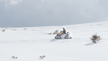 Man driving sports snowmobile in Finnish Lapland in a sunny day