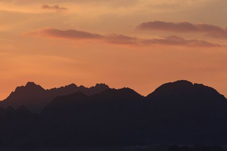 Sunset over the mountains. Orange sky.の写真素材