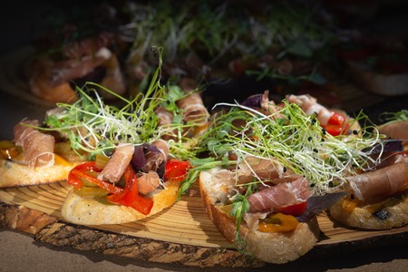 Close up bruschetta with proschuto, tomato, parmesan cheese and arugula.の写真素材