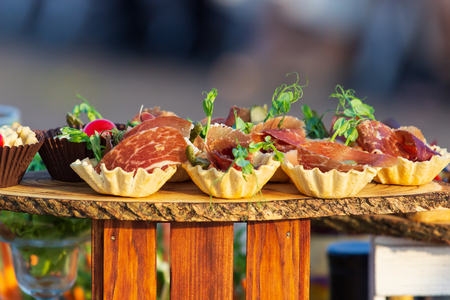 exquisite beautiful serve prosciutto in baskets on a wooden slice. Cateringの写真素材