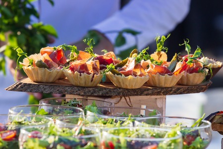 exquisite beautiful serve prosciutto in baskets on a wooden slice. Cateringの写真素材