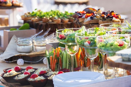 catering table set service with silverware and glass stemware at restaurant before party.