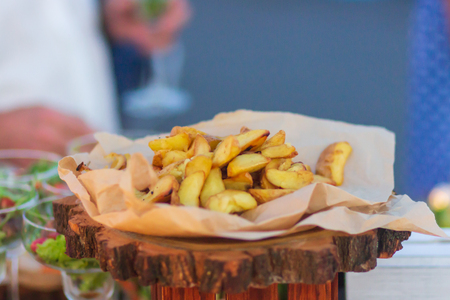 French fried potatoes in metal basket on wooden background.の写真素材