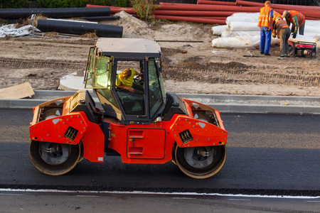 Industrial landscape with rollers that rolls a new asphalt on the road. Repair work, complicated...