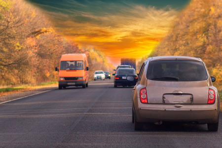 car on road and golden autumn space