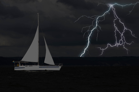 Sailing yacht in a stormy weather with lightningの写真素材