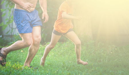 Father and son playing on the grass at the summer time. Concept of friendly family.の写真素材