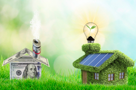 idea Invest in real estate, mortgage concept. green house with a solar roof, coins and dollars banknotesの写真素材